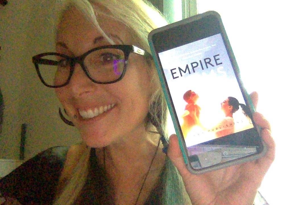 Woman showing her Empire Book on iphone